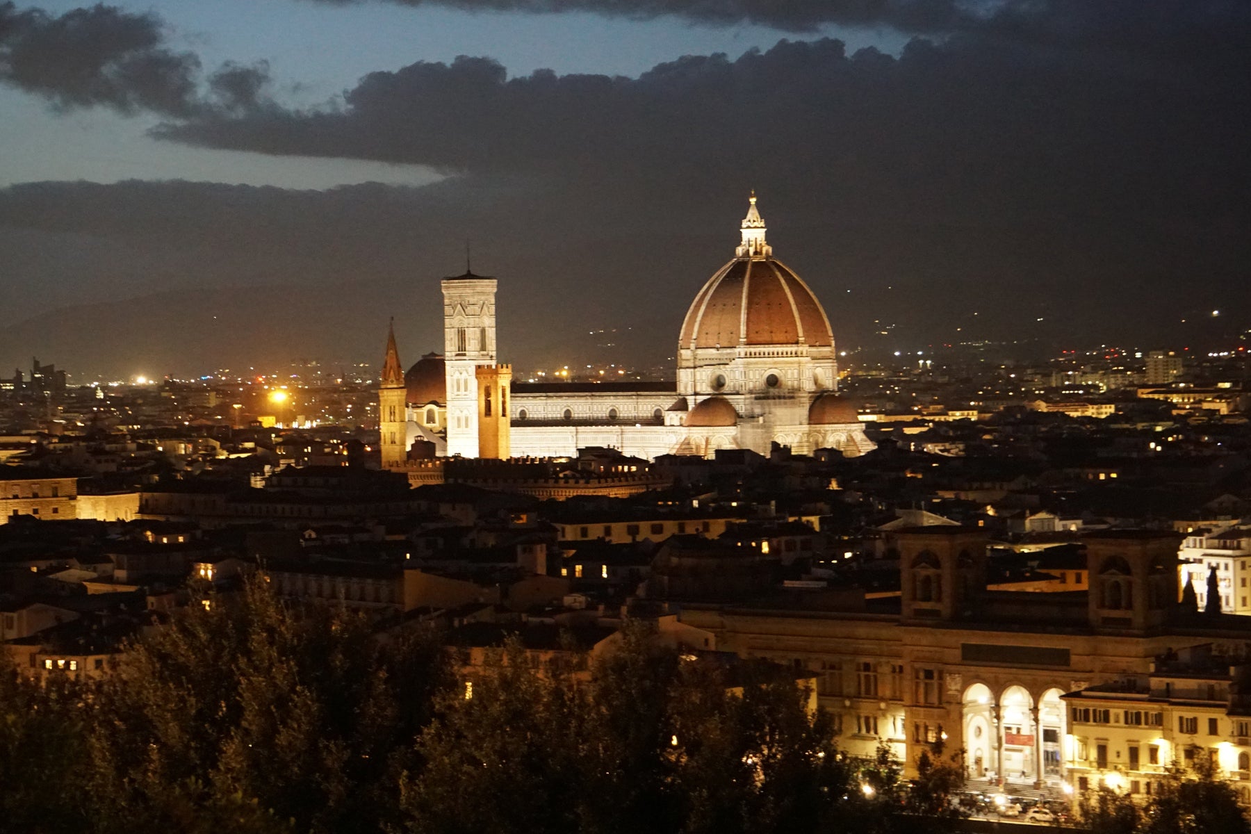 Florence Cathedral illuminated above the rooftops of Florence, Italy