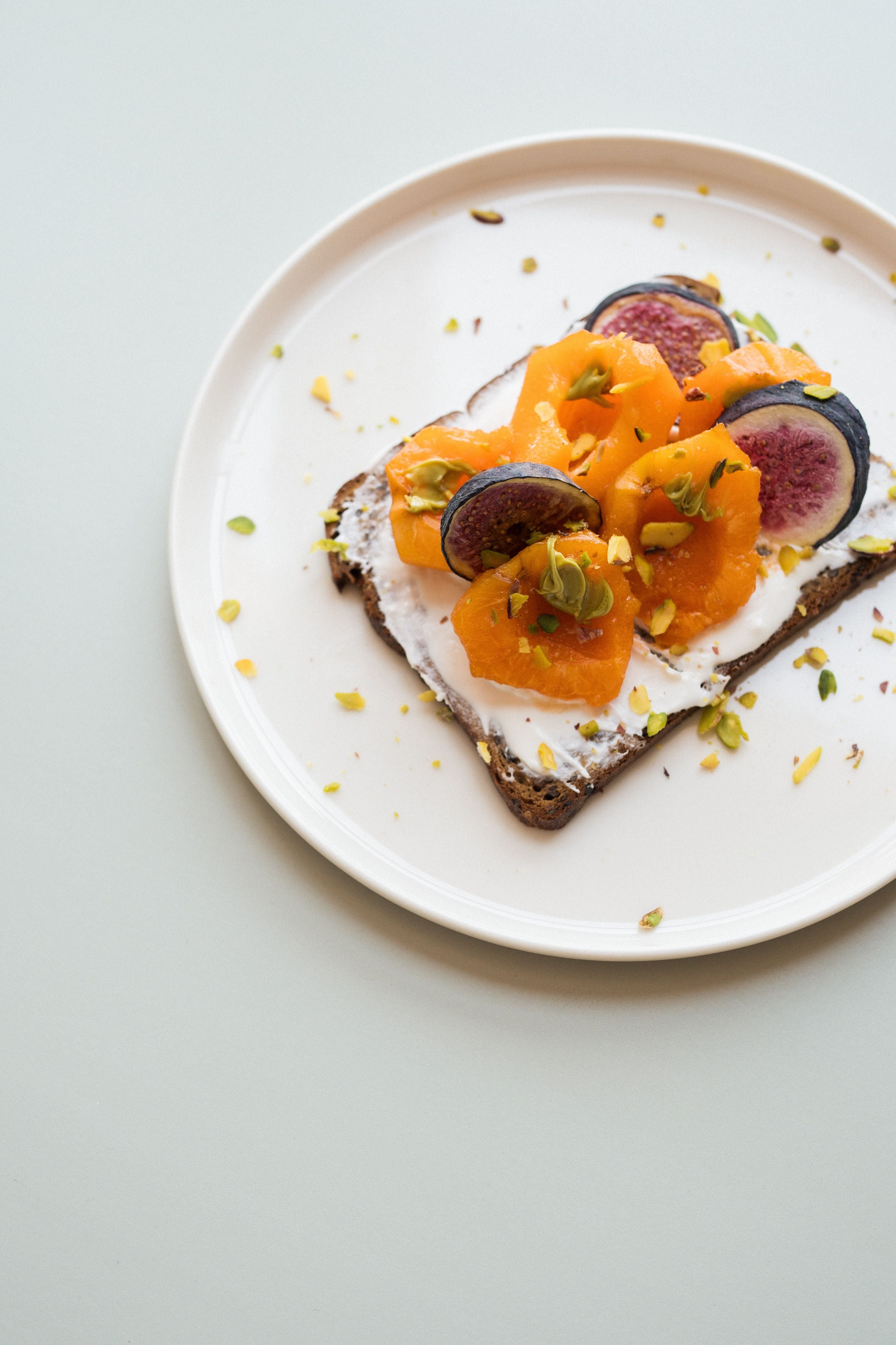 Pane tostato con formaggio fresco, cachi e fico
